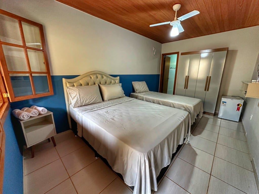Suíte Ipê Amarelo — quarto com parede azul
